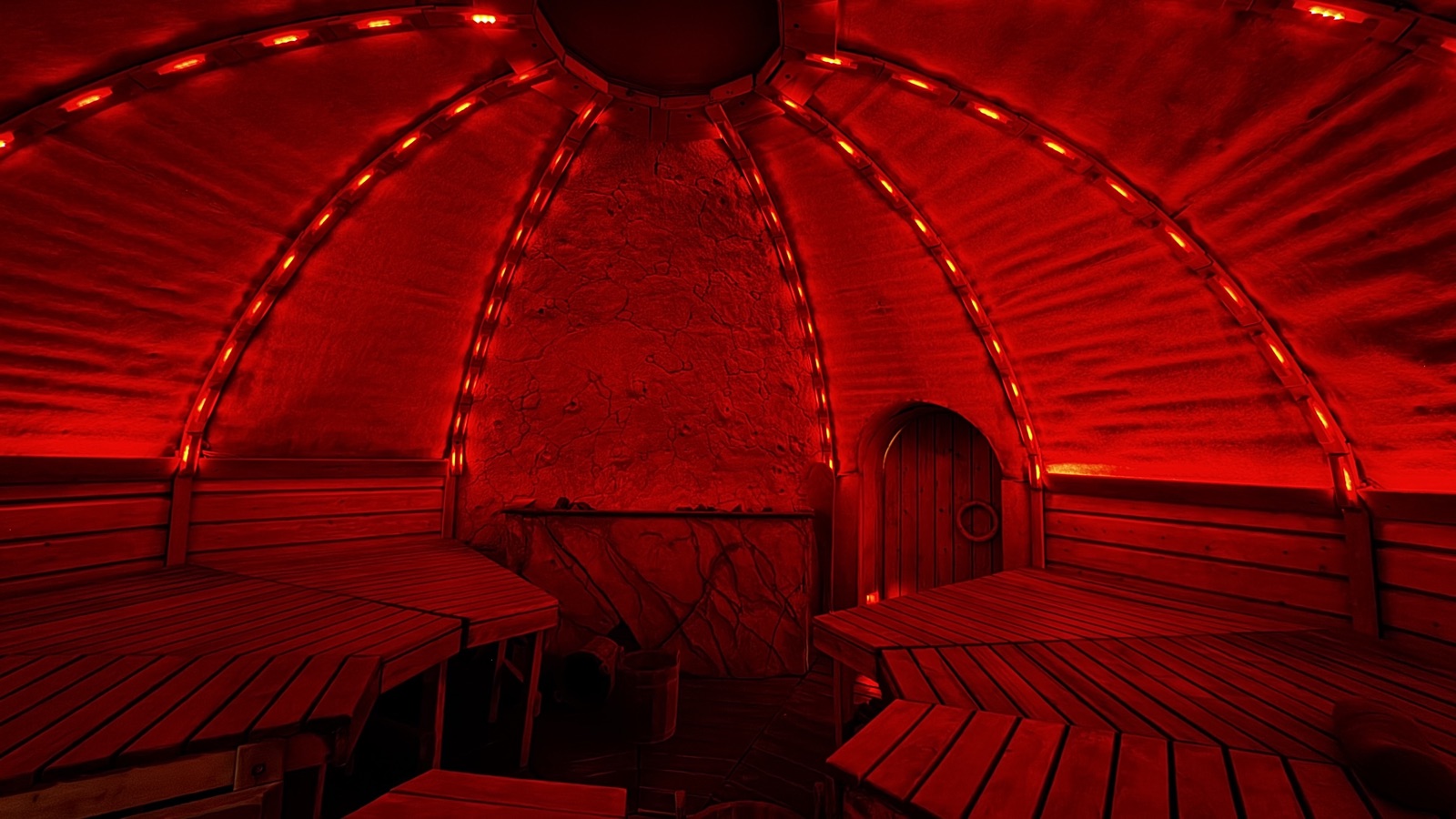 Inside an ATMOS steam dome under the SPI RGB light installation — addressable LED modules tracing the dome's ribs in deep red over tiered timber benches and a carved stone hearth